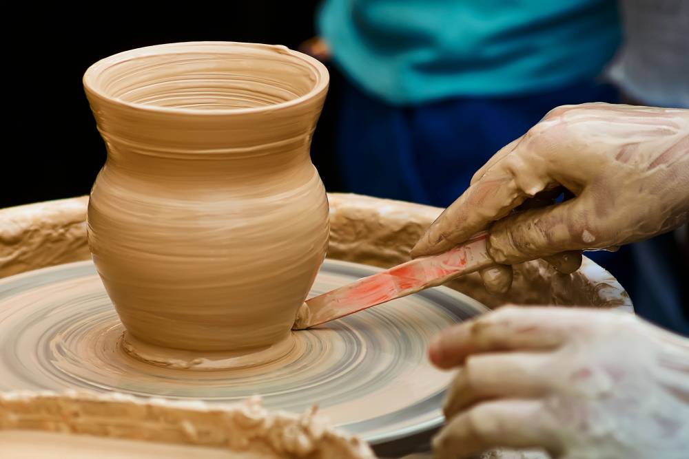 Potter shaping clay on a pottery wheel